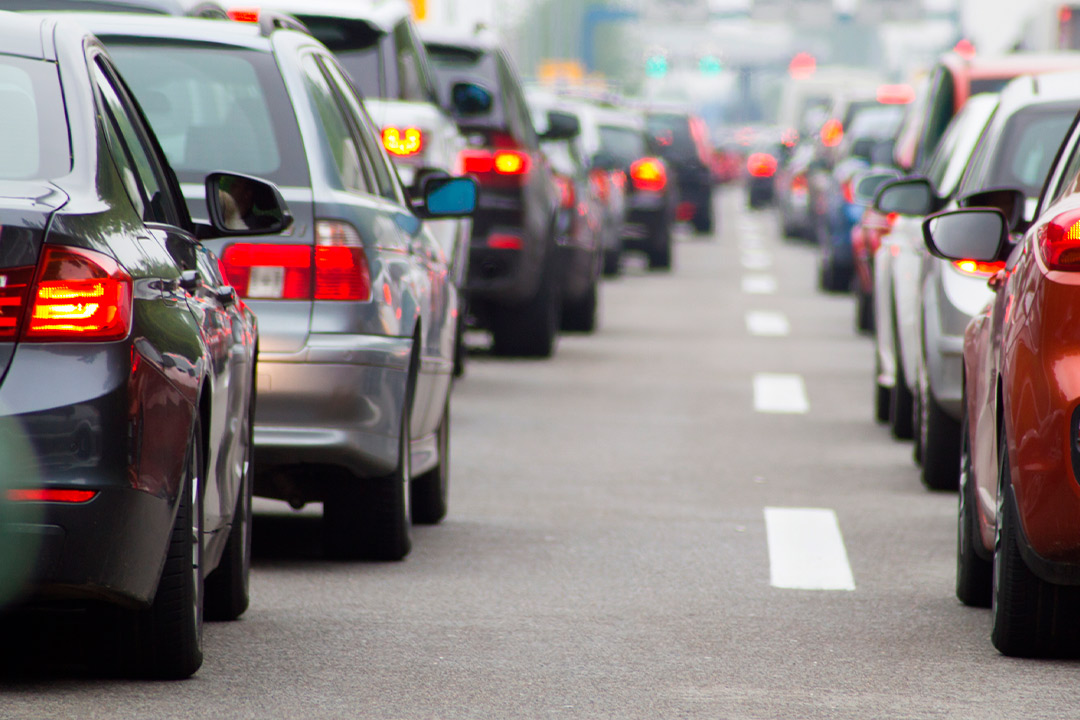 A congested street scene with numerous cars lined up, reflecting the heavy traffic typical of South Texas summers.