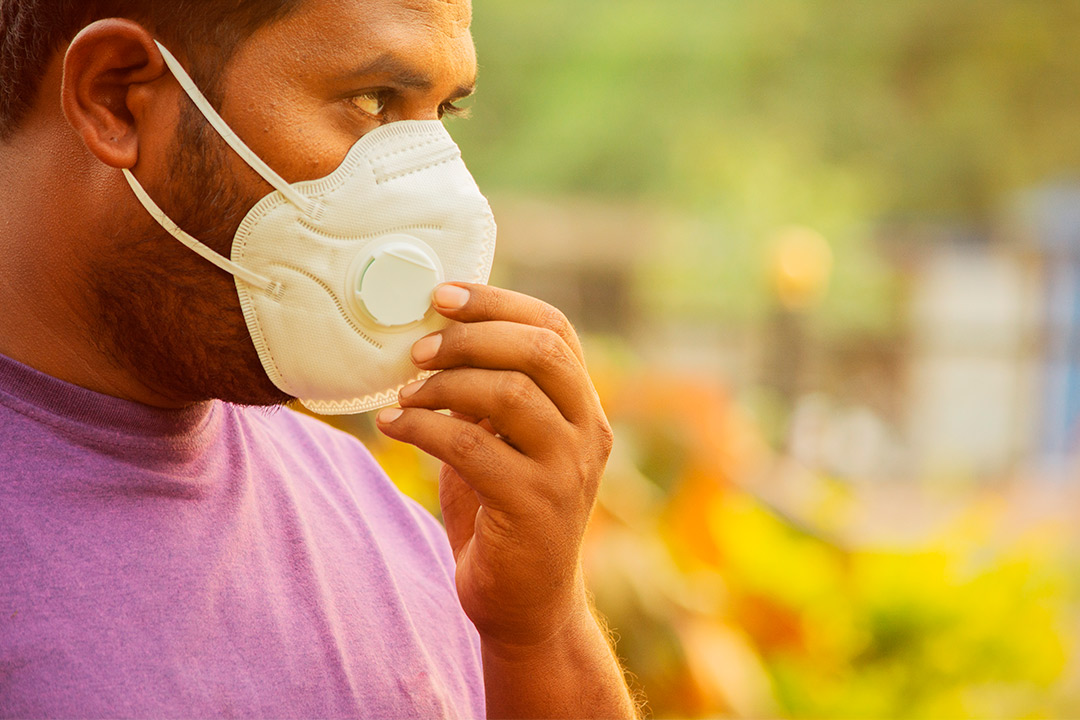 A man with a mask outdoors, emphasizing the importance of managing asthma triggers in South Texas heat